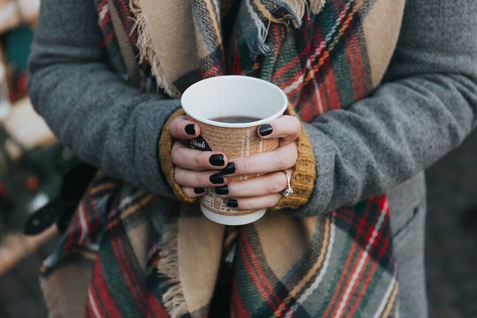 Caffè napoletano - Una ragazza che stringe tra le mani un bicchiere di Americano per riscaldarsi dal freddo