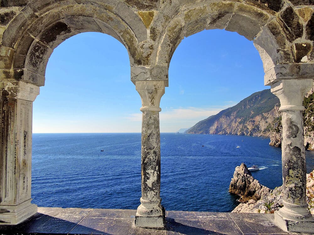 La costa della Costiera Amalfitana vista attraverso gli archi di un antico monastero