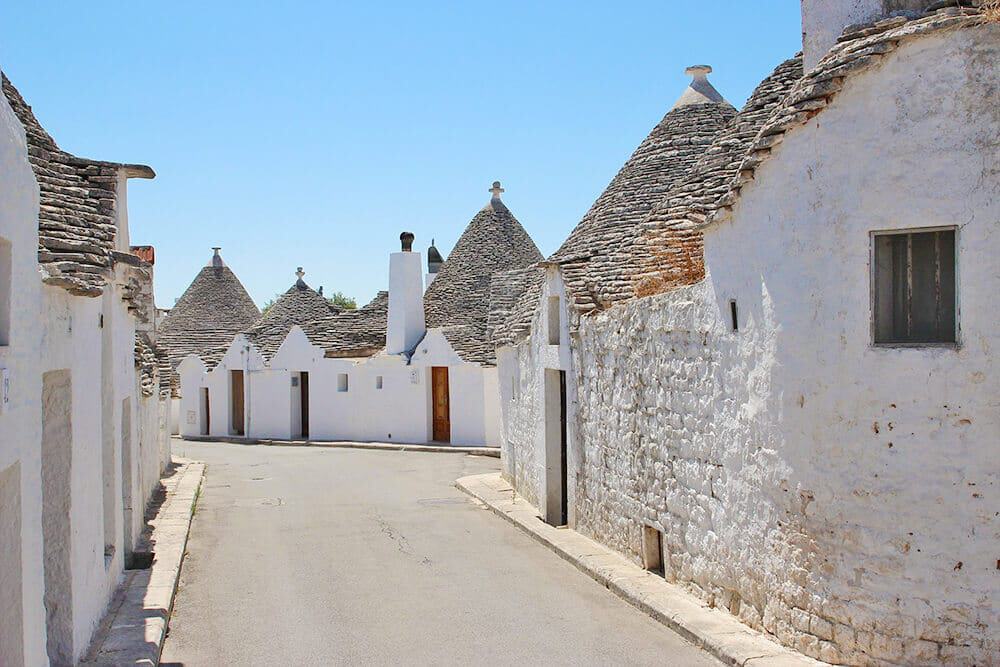 Una stradina piena di trulli ad Alberobello in Puglia