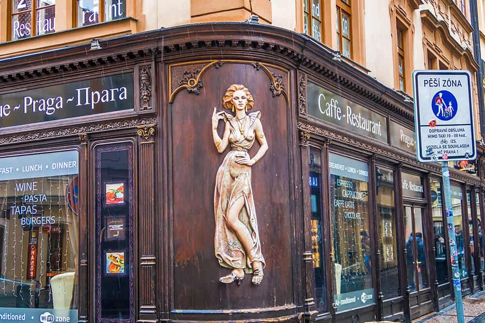 Wooden sign at an ancient shop in Prague in Winter while it's snowing