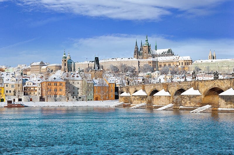 Charles Bridge and Prague in winter covered in snow