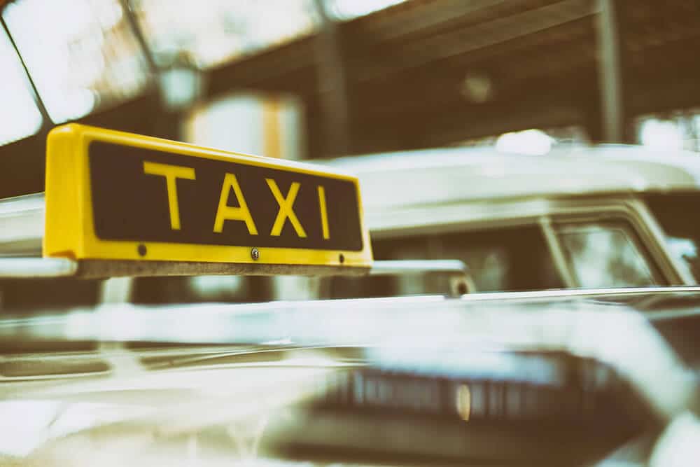 A yellow and black taxi sign on a blurred background