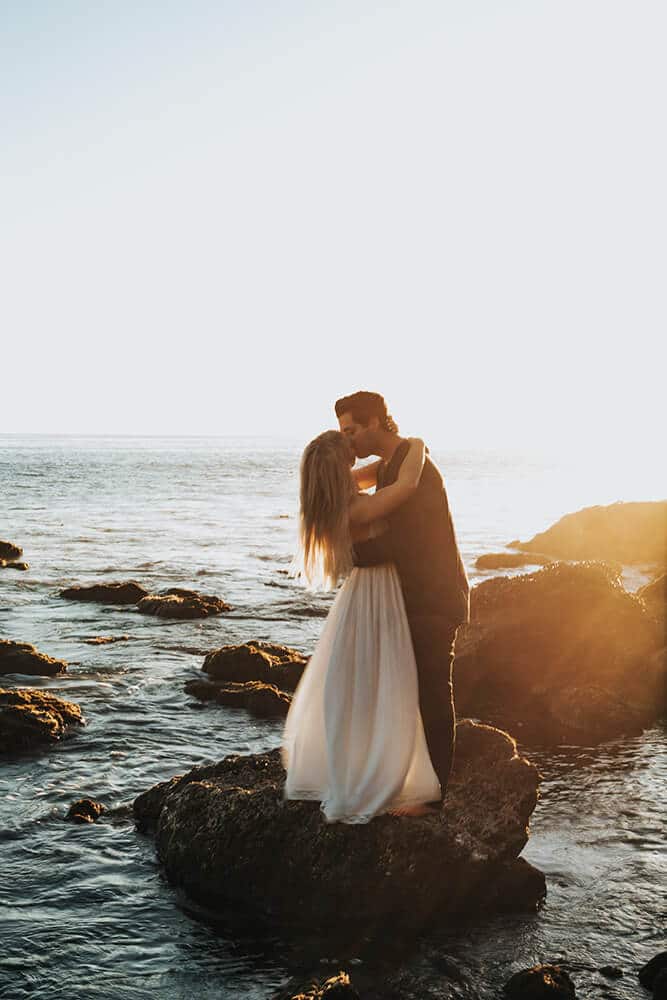 Amalfi Coast hotels - Newlyweds kissing on the seaside rocks on the Amalfi Coast