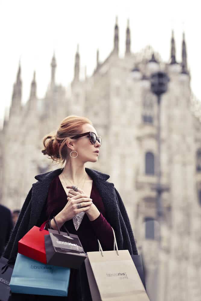 Donna elegante che fa shopping con il Duomo di Milano sullo sfondo
