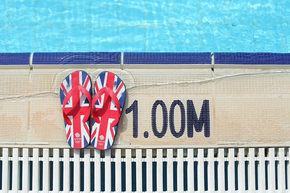 Flipflops with the Union Jack next to a swimming pool on a cruise ship