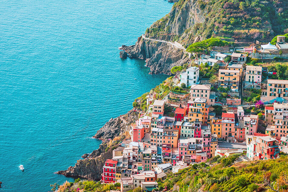 Drone shot of the colorful houses in Riomaggiore in Cinque Terre (Italy) next to the coast