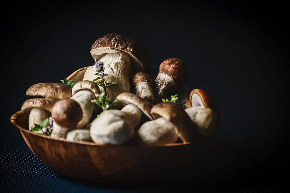 Porcini estivi in una ciotola con fiori di campo primaverili