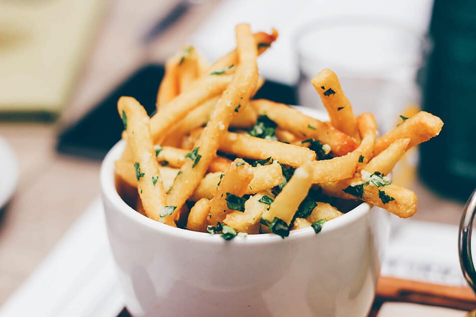 Una ciotola di patatine fritte condite con sale grosso ed erba cipollina in un pub a Cork, Irlanda