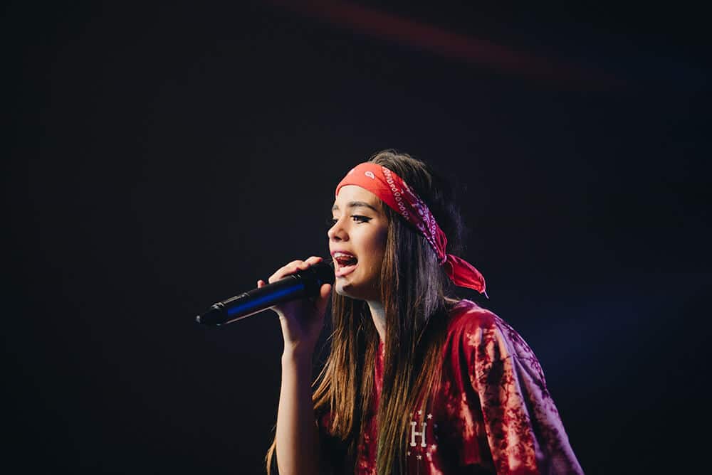 Woman with a red bandana on her head singing karaoke