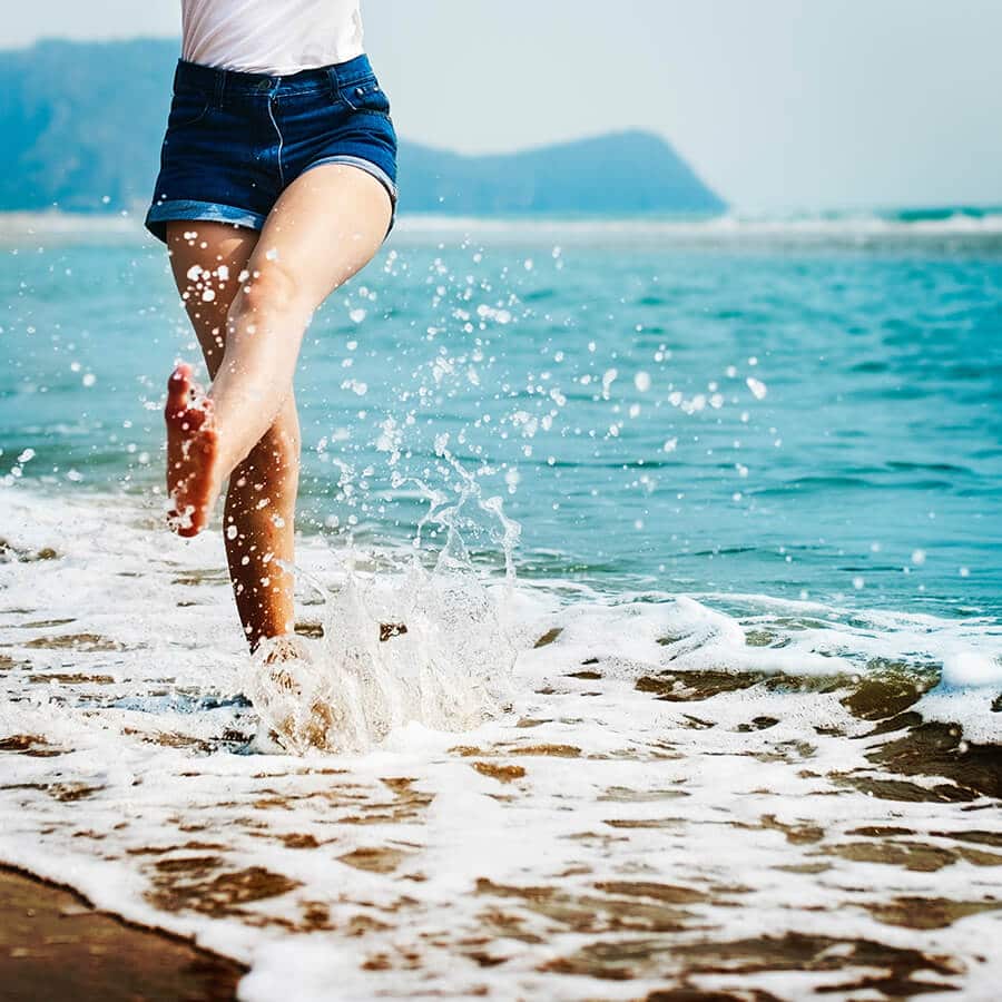 Ragazza gioca con l'acqua in spiaggia in un Costiera Amalfitana tour