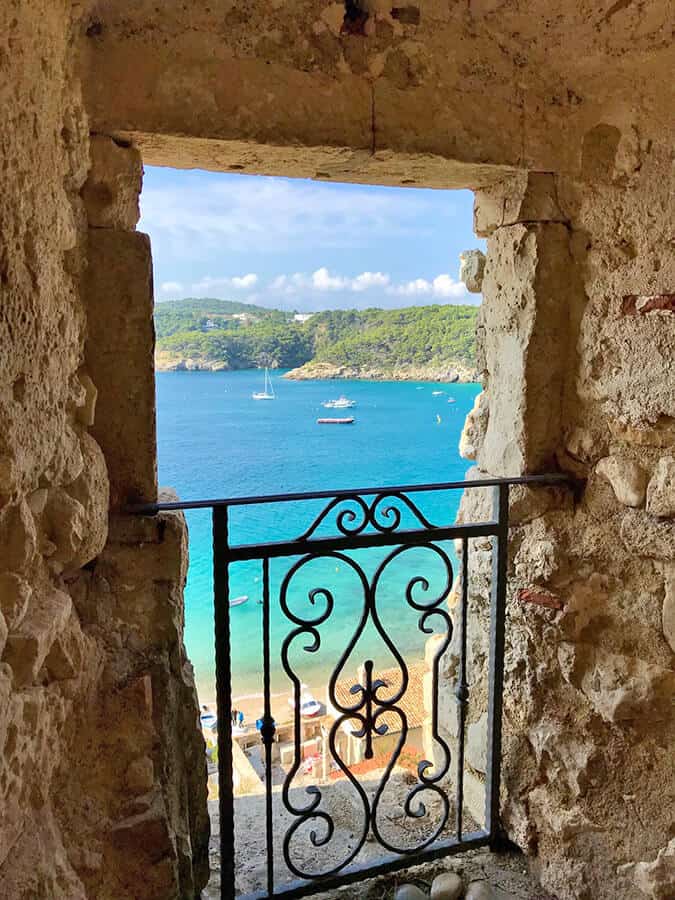 Barche al largo di Capri viste attraverso una cornice di pietra di tufo