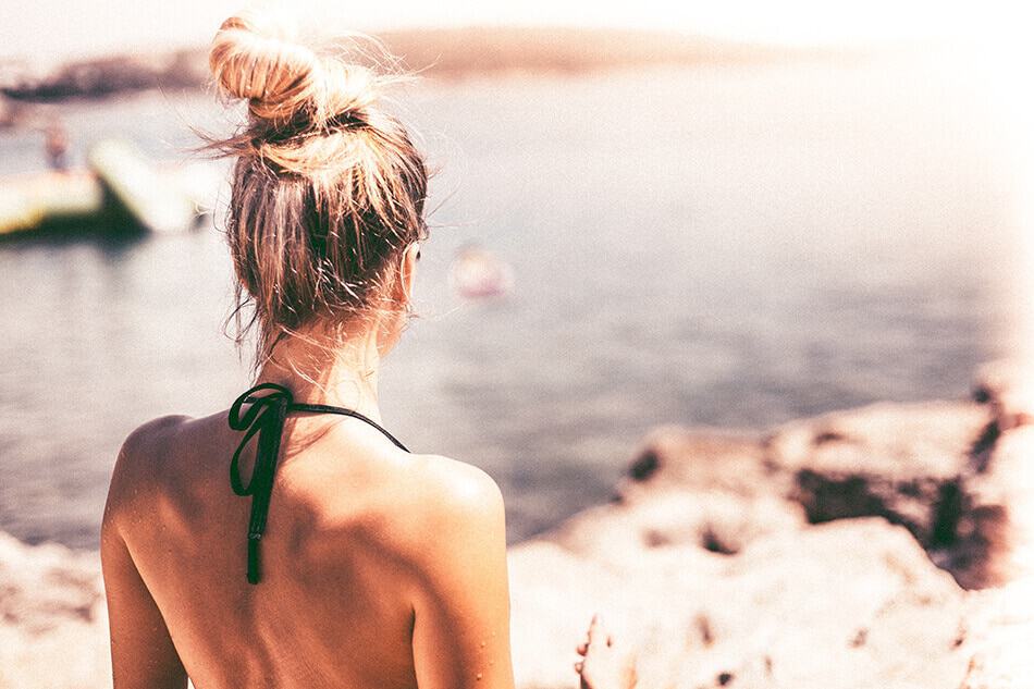 Ragazza bionda in bikini si abbronza in spiaggia a Capri