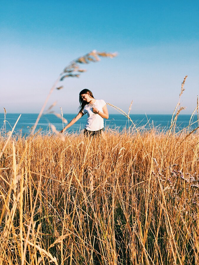 Una ragazza gioca con l'erba alta in estate su uno dei percorsi escursionistici della Costiera Amalfitana