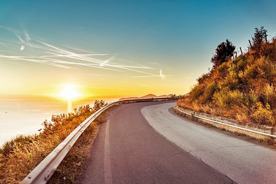 Strada solitaria sulla Costiera Amalfitana al tramonto: perfetta per un road trip panoramico!