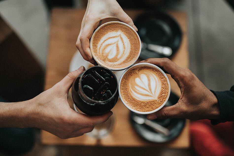 Amici brindano con cappuccino e Coca-Cola ghiacciata allo Spoon Cafè di Edimburgo (Scozia)