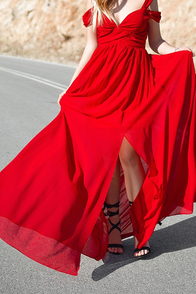 Close up of a woman wearing a flowy, bright red evening dress in Italy