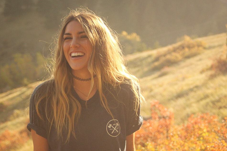 A girl laughing with a t-shirt on in the Tuscany countryside in summer