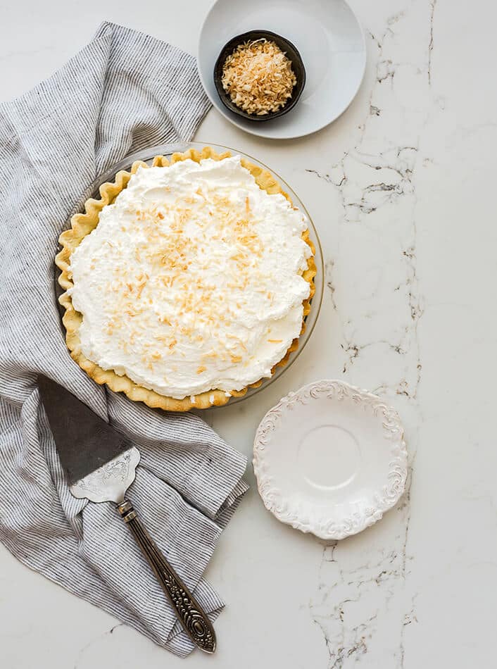 Key lime pie with pie crust and meringue topping on a marble table