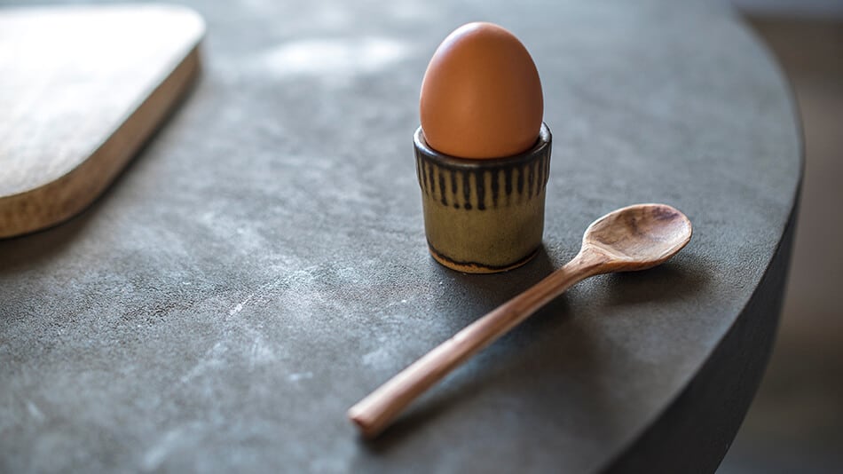 Ceramic egg holder with a wooden spoon