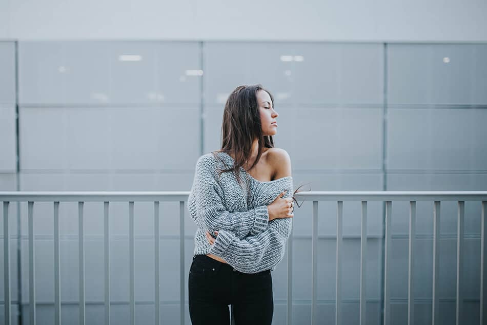 Woman wearing a soft wool jumper with a naked shoulder