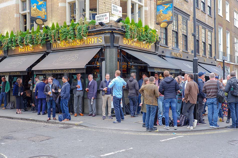 La vita notturna di Londra a Soho con londinesi che bevono birra all'esterno di un pub