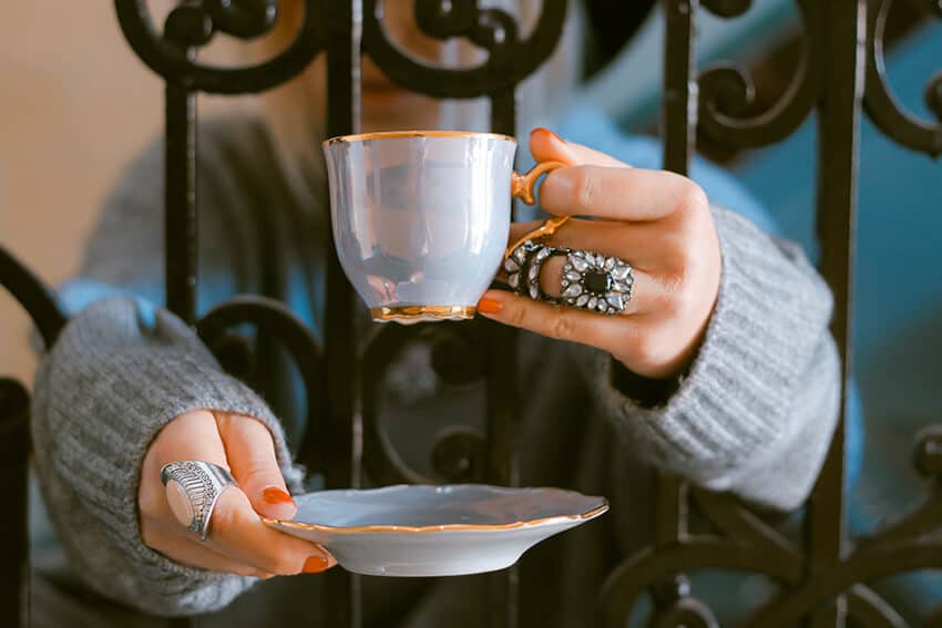 Donna che beve un tè a Londra in una tazzina da tè finemente decorata