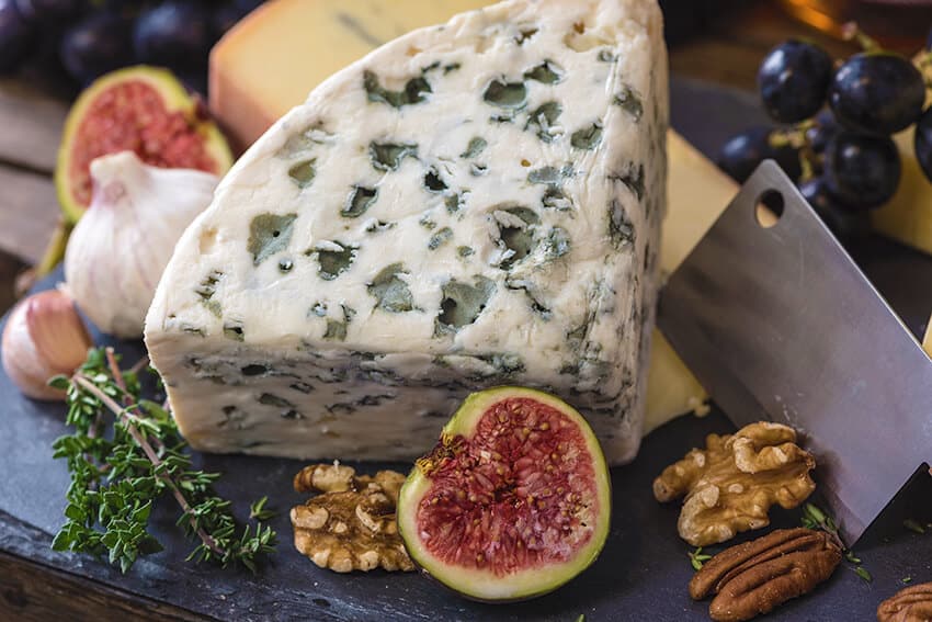 A slice of Stilton Blue cheese from London can be eaten with figues and nuts