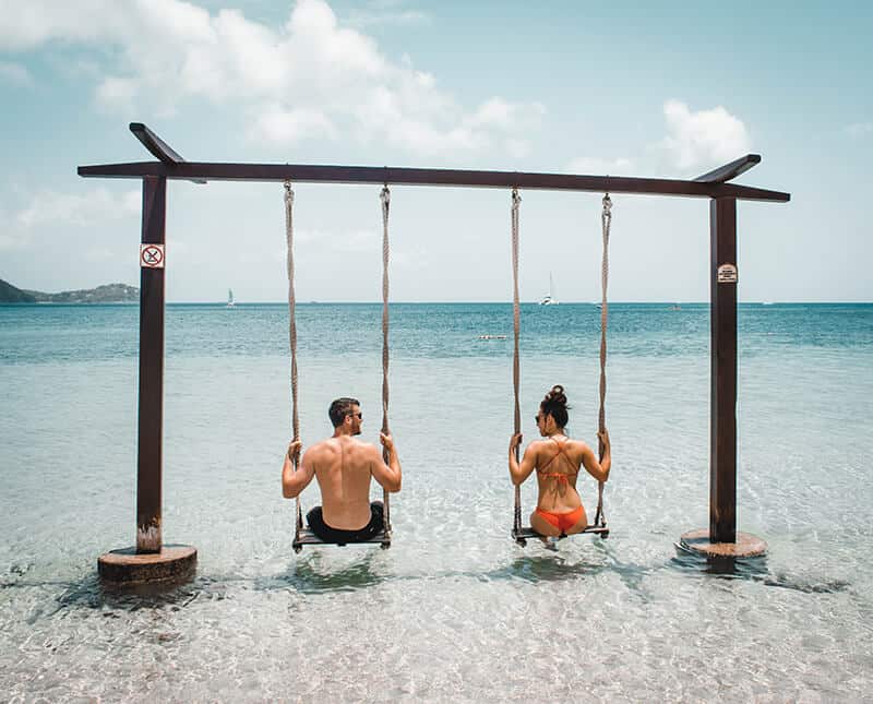 Couple sitting on swings in the ocean - Miami Beach, Florida