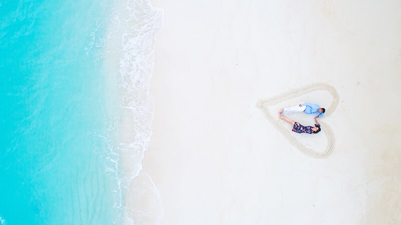 Couple laying on white sand in Florida