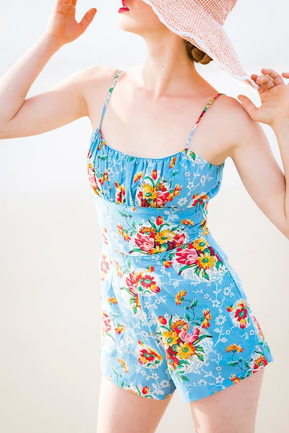 Beautiful cotton overal shorts in baby blue with flowers and a straw beach hat