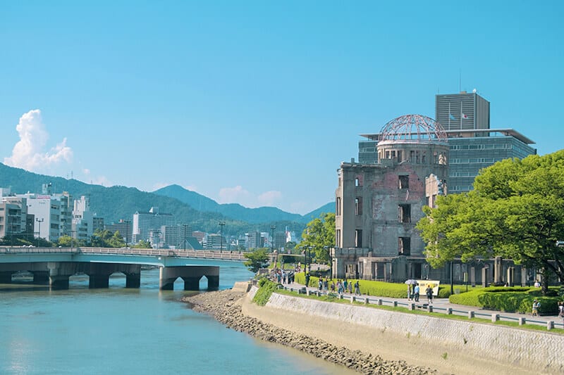 View of the Atomic Bomb dome and a stone bridge in Hiroshima on a sunny day trip from Kyoto