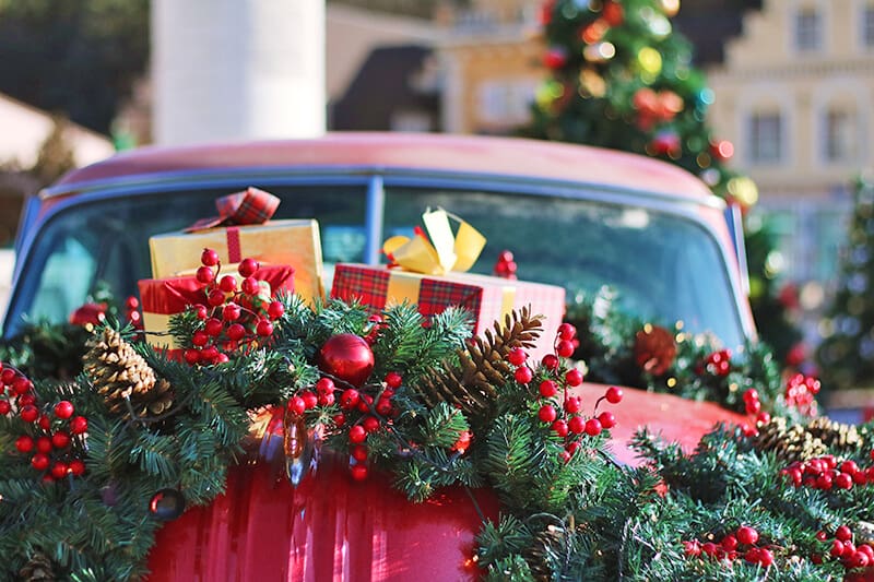 Auto rossa decorata con palline di Natale e doni