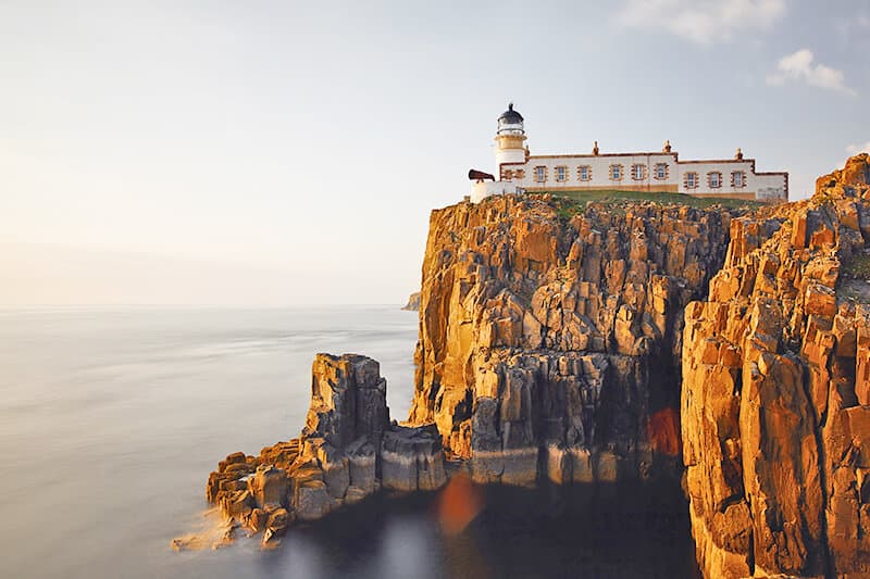 Un faro su una scogliera scoscesa al tramonto durante un viaggio in Scozia