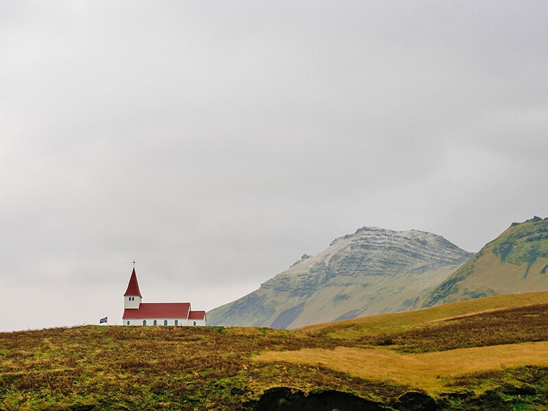 View of a green valley in Scotland with a little Church in the distance