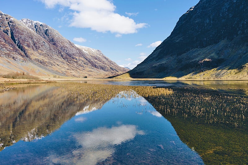 Sky reflected on the surface of a lake on a Scotland road trip