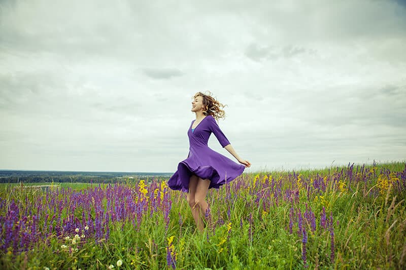 Girl enjoying the day in a flowy purple dress in the Irish countryside