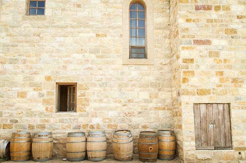 Botti accanto a un muro in pietra