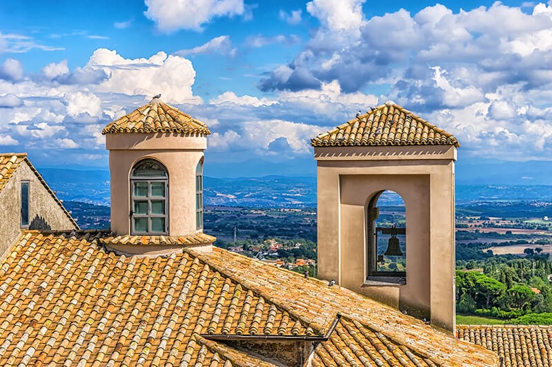 Il Campanile di una Chiesa con la campagna toscana alle spalle