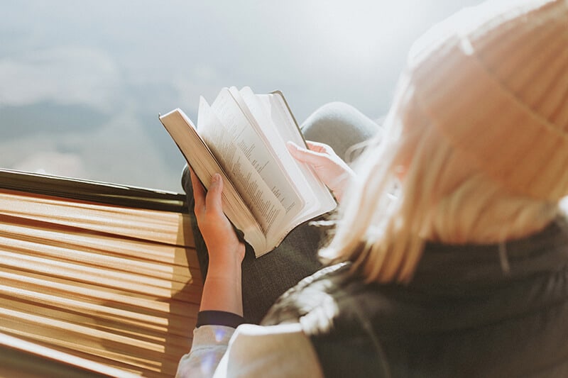 Girl reading a book bought in Ireland as souvenir