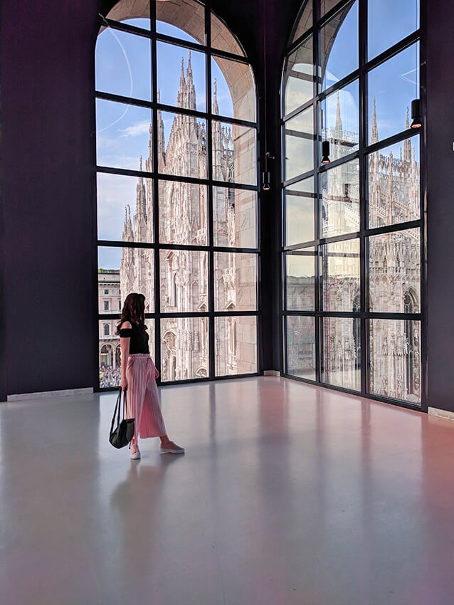 Girl looking at the Duomo in Milan from a nearby building