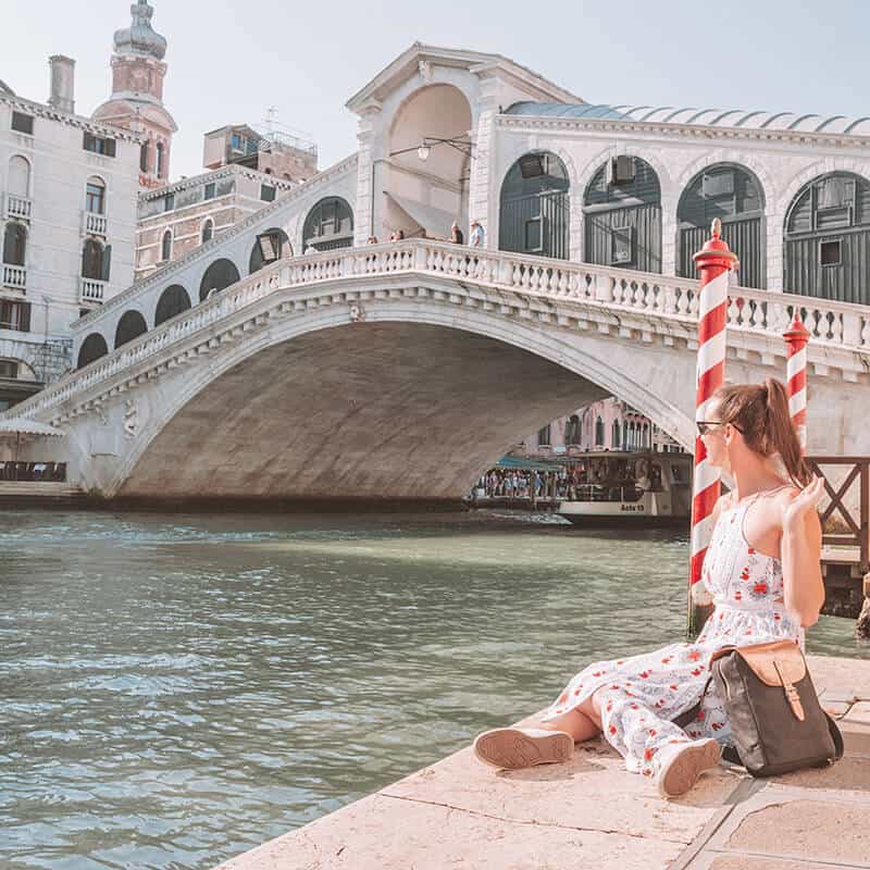 Girl sitting next to Rialto Bridge in Venice
