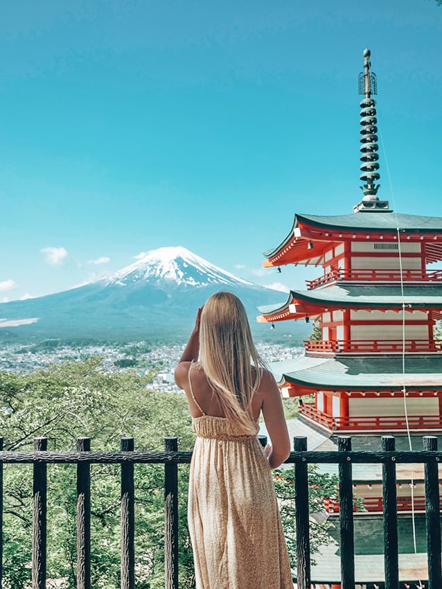 Woman looking at a pagoda with Mt Fuji on the background