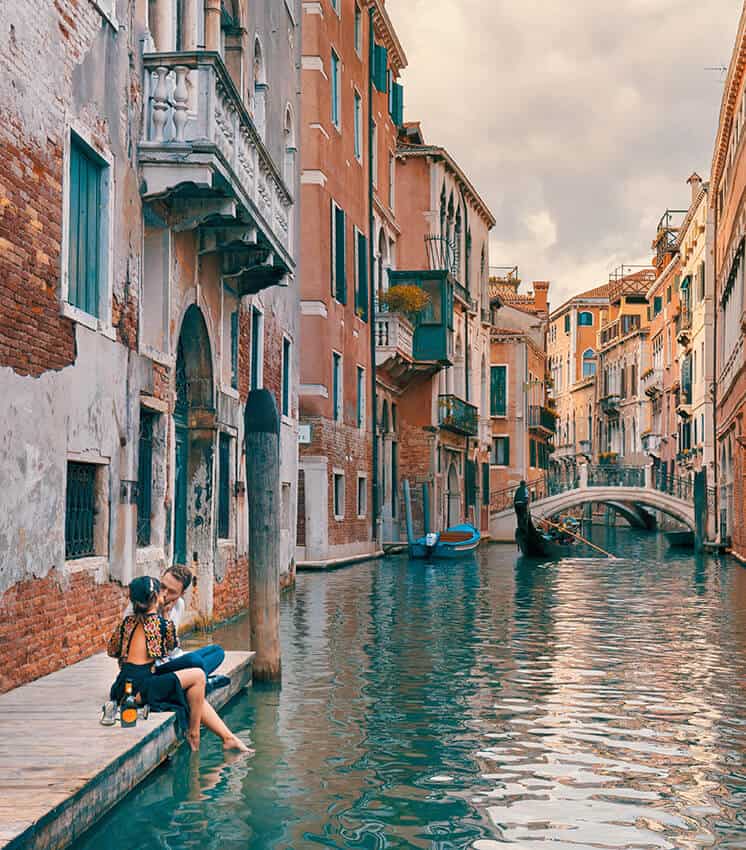 Coppia in atteggiamenti romantici lungo un canale di Venezia