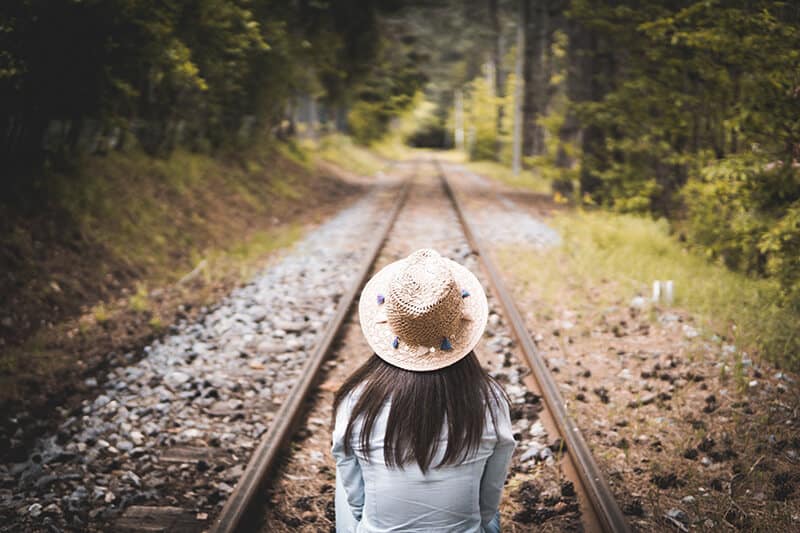 Ragazza seduta sui binari di una ferrovia in Olanda