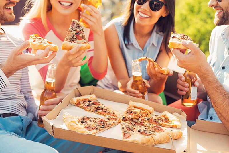 Friends eating one of the types of Italian pizzas together