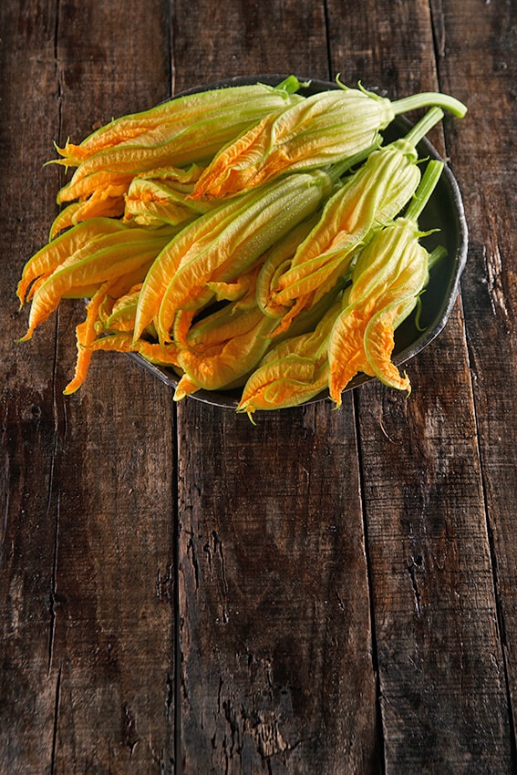 Pumpkin flowers in a bowl on a wooden table