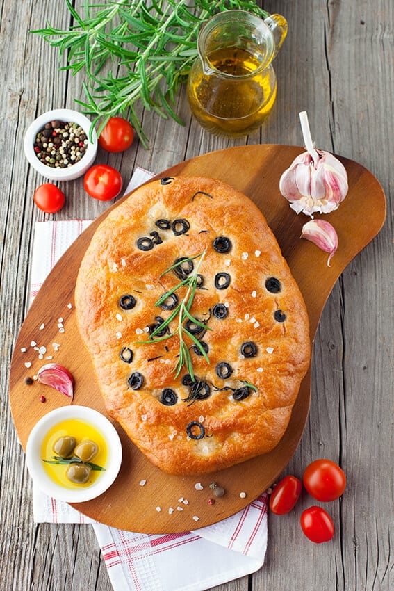 Italian focaccia with salt and black olives on the top