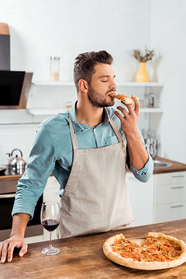 Man eating Italian pizza at home