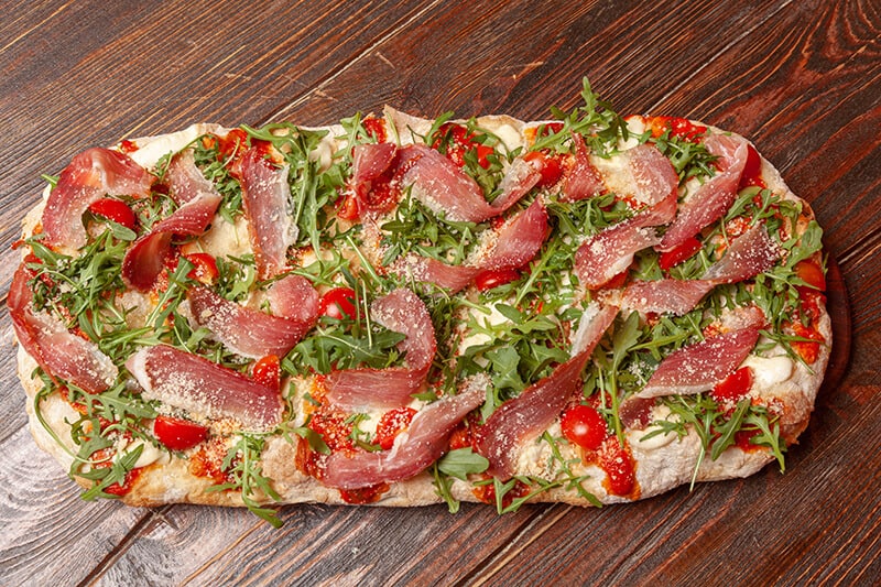 Pizza in Rome is alla pala with arugula, prosciutto and cherry tomatoes