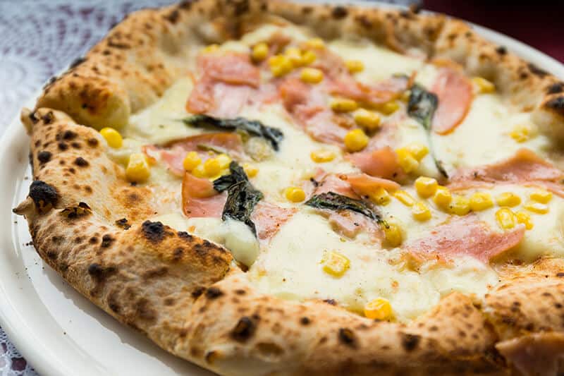 Neapolitan pizza with mozzarella, baked ham and sweet corn